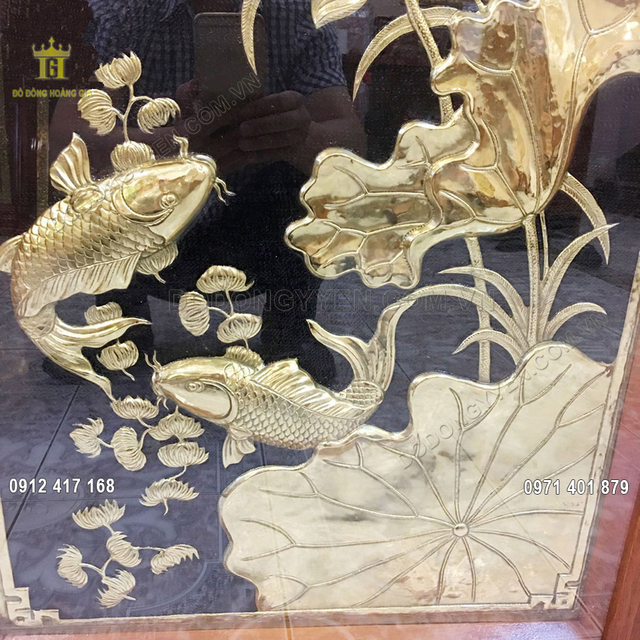 Sản phẩm được chạm th&uacute;c thủ c&ocirc;ng từ đồng v&agrave;ng nguy&ecirc;n tấm d&agrave;y 8 rem, mỗi chi tiết nhỏ tr&ecirc;n bức tranh như c&aacute; ch&eacute;p, hoa sen đều được chạm th&uacute;c v&ocirc; c&ugrave;ng tỉ mỉ bởi c&aacute;c nghệ nh&acirc;n l&acirc;u năm